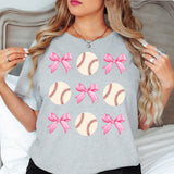 a woman wearing a gray shirt with pink bows on it
