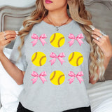 a woman wearing a t - shirt with softballs and bows on it