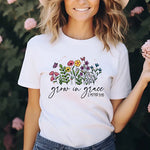 a woman wearing a white t - shirt with flowers on it