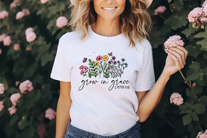 a woman wearing a white t - shirt with flowers on it