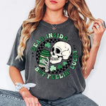 a woman wearing a grey shirt with a skull and shamrocks on it