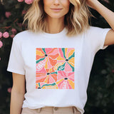 a woman standing in front of a bush with pink flowers
