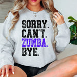 a woman sitting on a bed wearing a sweatshirt that says sorry can't zu