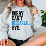 a woman sitting on a bed wearing a sweatshirt
