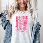 a woman wearing a t - shirt that says teaching is awesome