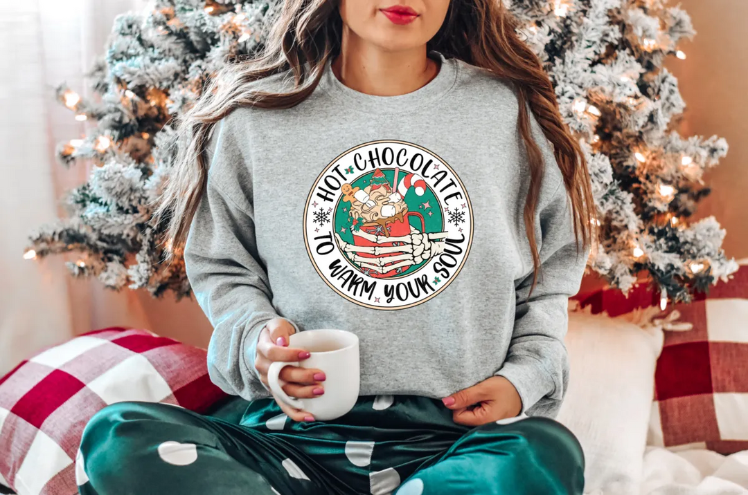 a woman sitting on a bed holding a cup of coffee