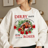 a woman sitting on a bed wearing a sweatshirt