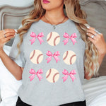 a woman wearing a gray shirt with pink bows on it