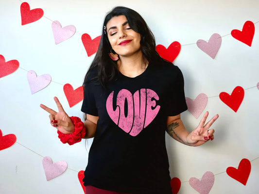 a woman standing in front of a wall with hearts