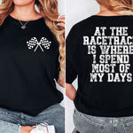 a woman wearing a black shirt that says at the race track is where i spend