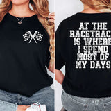 a woman wearing a black shirt that says at the race track is where i spend