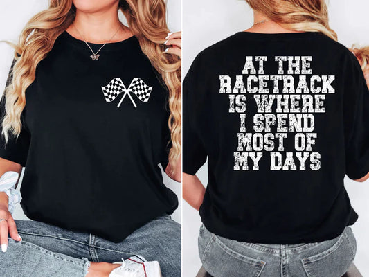 a woman wearing a black shirt that says at the race track is where i spend