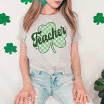 a woman wearing a teacher's t - shirt with a shamrock on it