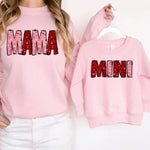 a woman wearing a pink sweatshirt with the word mama printed on it