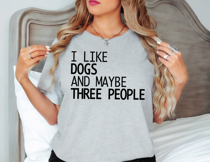 a woman wearing a t - shirt that says i like dogs and maybe three people