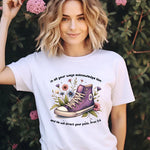a woman wearing a t - shirt with a pair of shoes on it