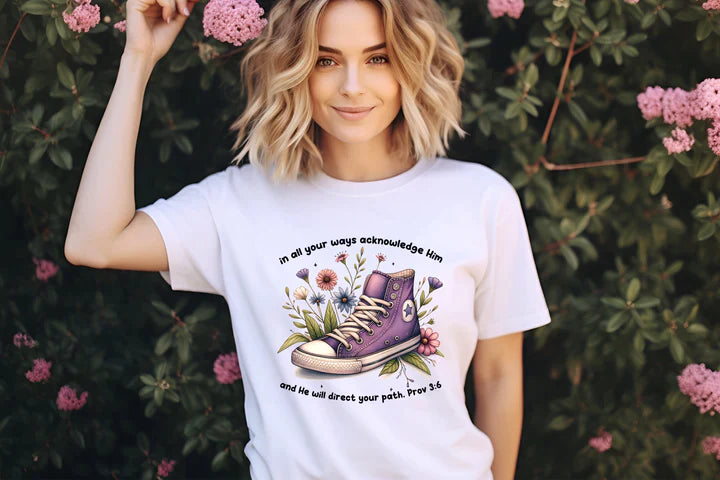 a woman wearing a t - shirt with a pair of shoes on it