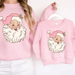 a woman wearing a pink sweatshirt with a santa clause on it