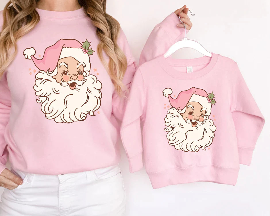 a woman wearing a pink sweatshirt with a santa clause on it